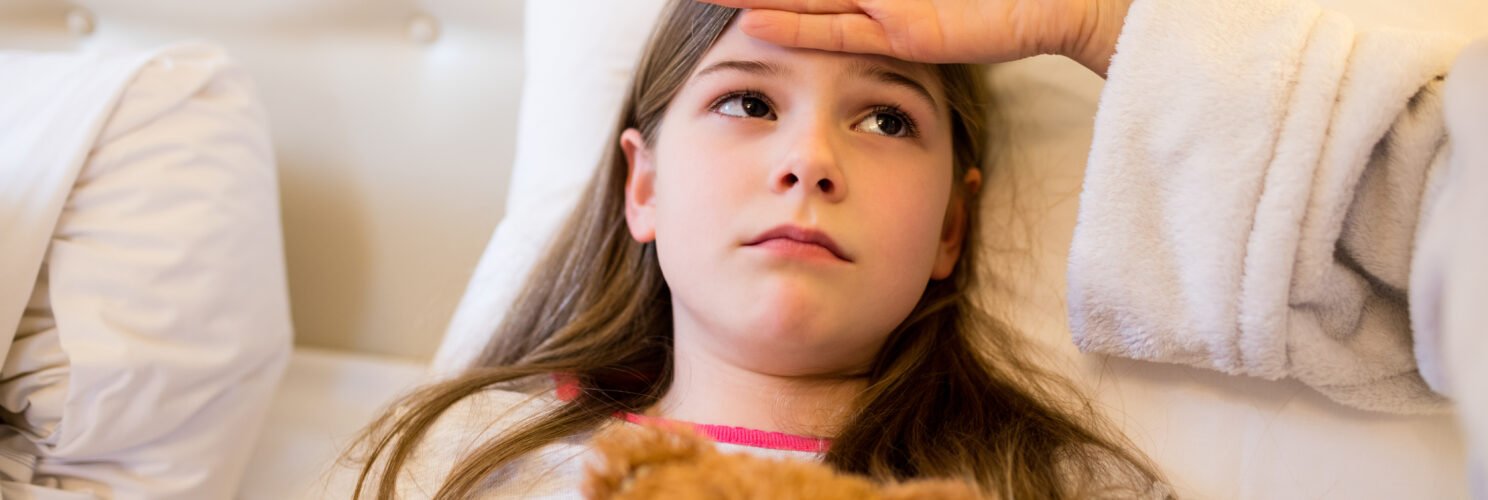 Matka opiekująca się córką w łóżku podczas gorączki